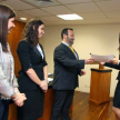 El abogado Andrés Vázquez otorga el certificado a una de las representantes de la universidad ganadora.