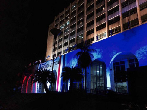 Luces con los colores patrios y la bandera nacional engalanan en horas de la noche la fachada del Palacio de Justicia de Asunción.