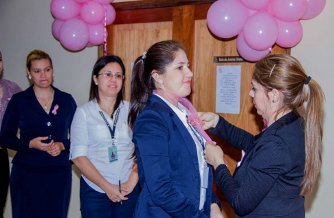 Colocan a una funcionaria el lazo rosa, símbolo de lucha contra el cáncer de mama.