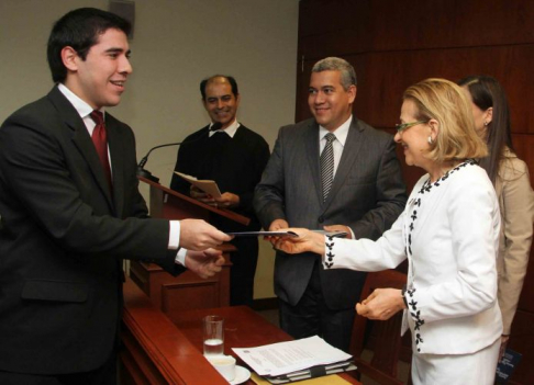 La ministra Alicia Pucheta de Correa entrega su pasaje al estudiante Ricardo Sanabria, de la Universidad Católica.