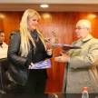El ministro de la Corte, Miguel Oscar Bajac y la presidenta de la Cooperativa Universitaria, doctora Marta Sosa intercambiando las carpetas del acuerdo.