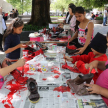 Personas voluntarias pintando los calzados donados por la ciudadanía.