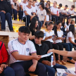 Alumnos recibiendo materiales educativos.