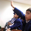 Un niño pidiendo la palabra para realizar una pregunta en la charla.