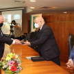 El ministro Luis María Benítez Riera realizando la entrega de reconocimiento a un magistrado. 