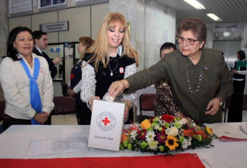 Momento en que la defensora general de la República, Noyme Yore, deposita su donación en la mesa instalada en la sede judicial de Asunción.