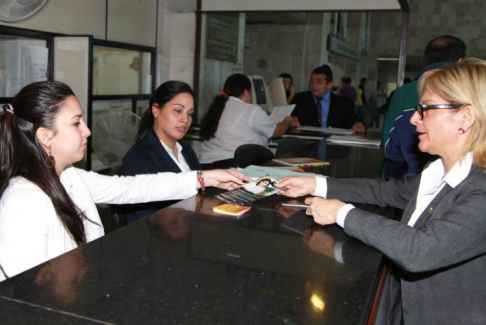 La funcionaria Alba Arriola entrega un material sobre el trabajo infantil a una abogada.