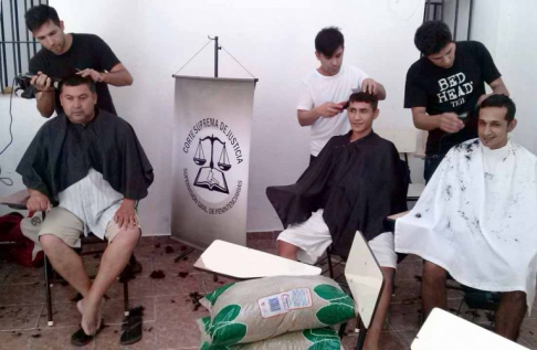 Peluqueros en pleno corte de pelo de los internos.