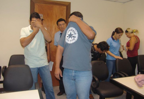 Momentos antes del inicio de la audiencia, de cara tapada los policías acusados, de remera roja la acusada.