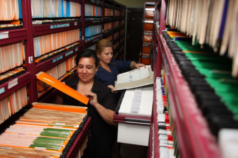 Funcionarias revisando archivos de Registros Públicos