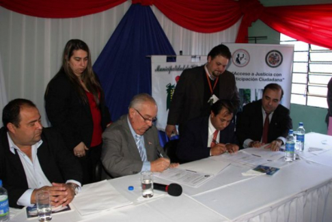 Momento de la firma del Convenio entre el Ministro Bajac, responsable de los facilitadores judiciales y el intendente de Villa Elisa