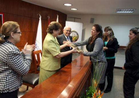 Momento en que la Defensora General de la República, Noyme Yore recibió una plaqueta de reconocimiento por su labor