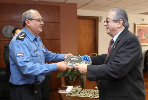 Momento en que el titular de la Corte, Raúl Torres Kirmser entrega un obsequio al Comisario Ubaldo Garcete