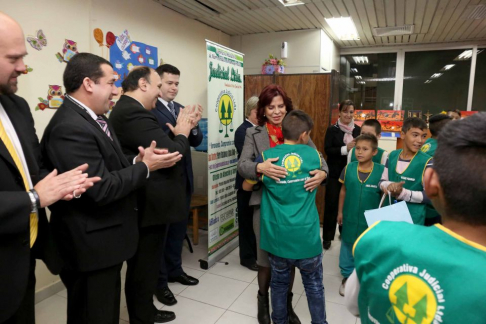 La ministra Miryam Peña entregando los chalecos a los niños lustrabotas.