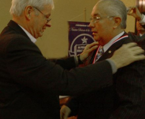 Momento en que el rector de la Universidad Católica, doctor Michel Gibaud entrega la medalla de reconocimiento al ministro Miguel Oscar Bajac
